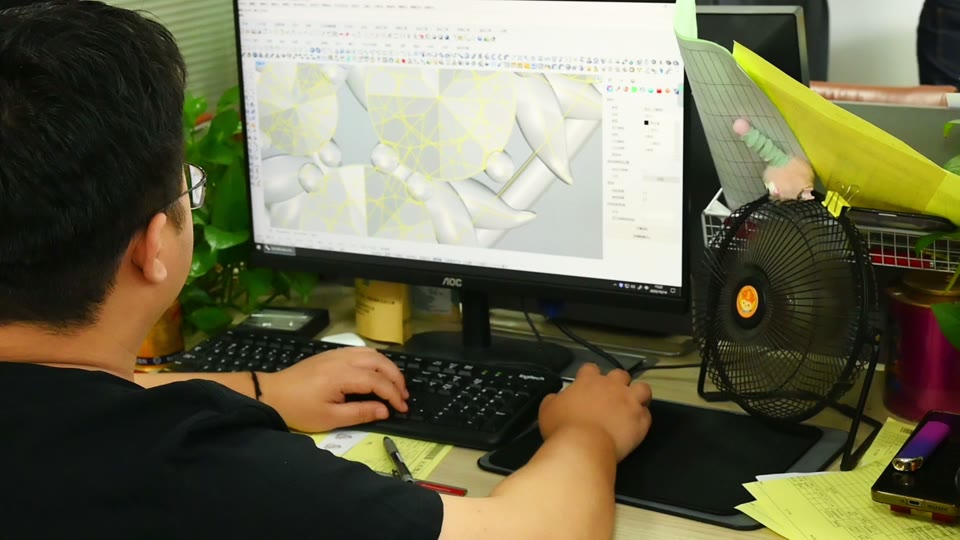A member of the team working with a jewelry design on screen.